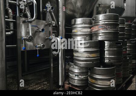 Pile industrielle en acier de fûts de bière contre. Brasserie moderne et machines-outils pour la production d'alcool. Banque D'Images