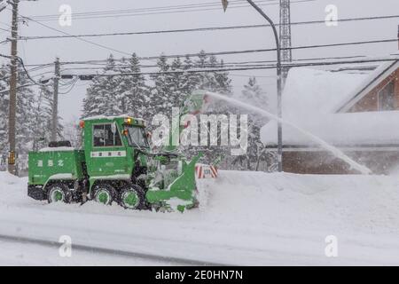 Une machine à déneiger déblayant les routes après une tempête de neige intense au Japon Banque D'Images