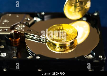 Pièces Bitcoin sur disque dur ou disque dur, macro. Concept de cybersécurité, confidentialité des données. Banque D'Images