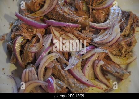 Salade de bœuf bouillie froide gastronomique avec oignon et huile d'olive sur l'assiette, gros plan. Banque D'Images