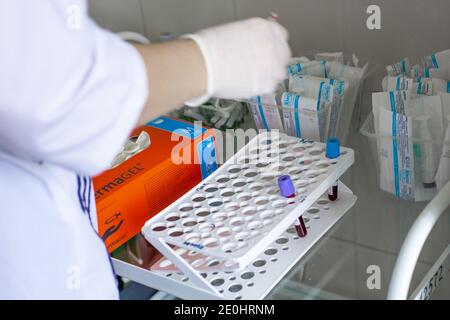 Okrug autonome de Khanty-Mansi, Russie-09.06.2020 : une infirmière dans une salle de traitement effectue un test sanguin. Sur une table en verre, il y a un portoir avec des tubes à essai Banque D'Images