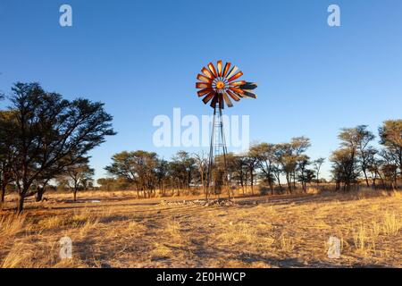 L'ancien moulin à vent du trou d'eau de Rooidam près de Nossob au coucher du soleil, Kgalagadi atrnsFrontier Park, Kalahari, Northern Cape, Afrique du Sud Banque D'Images