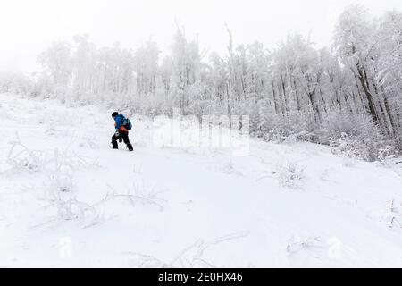 Garçon randonnée en montée sur neige Banque D'Images
