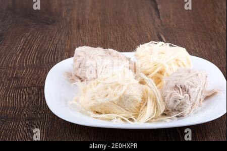 Bonbons de coton au cacao et à la vanille sur une assiette blanche. Une assiette de bonbons sur une table en bois. Bonbons turcs. Banque D'Images