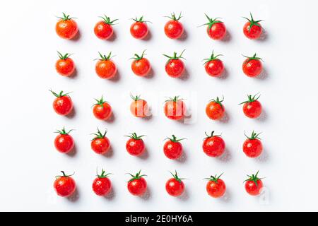 Tomates très fraîches dans la composition symétrique sur fond blanc, vue de dessus. Banque D'Images