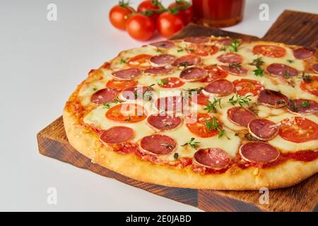 Gros plan de pizza chaude au pepperoni italien maison avec salami, mozzarella sur table blanche Banque D'Images