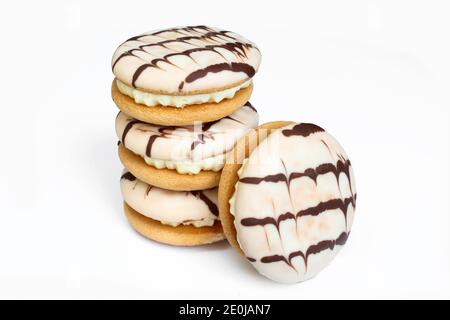 Délicieux gâteaux de crème isolés sur fond blanc. Biscuits sandwich recouverts de chocolat Banque D'Images