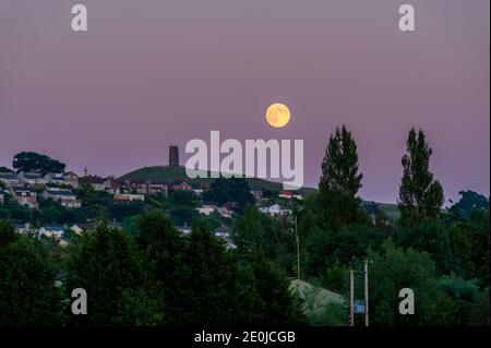 Lune qui s'élève au-dessus de Glastonbury Tor à partir des niveaux de Somerset Banque D'Images