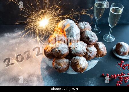 Le réveillon du nouvel an avec pile d'oliebollen (beignets de pâte hollandais) avec l'année 2022 écrit en sucre glace Banque D'Images