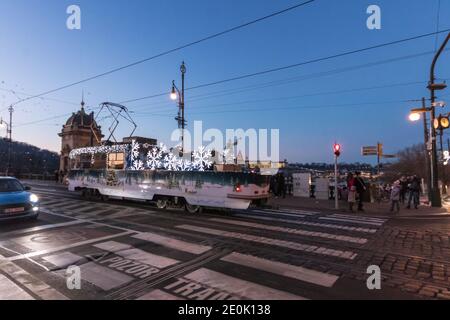 PRAGUE - décembre 30 : tramway de maintenance Tatra T3 avec décoration de Noël et lumières entrant sur le pont de la Légion près du Théâtre national le 30 décembre, Banque D'Images