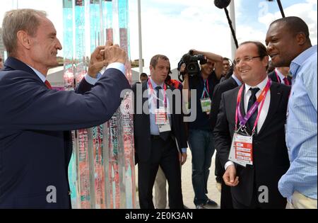 L'ancien skieur Jean-Claude Killy (L) prend une photo du président français François Hollande et d'un invité le 30 juillet 2012 au village olympique de Londres, pendant les Jeux Olympiques de Londres 2012. Photo de Gabriel Bouys/Pool/ABACAPRESS.COM Banque D'Images