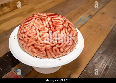 Un gâteau en forme de cerveau avec fraise source brossée sur elle pour faire l'aspect de gâteau éponge comme un vrai cerveau humain sanglant pour la partie halloween Banque D'Images