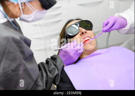 Dentiste utilisant UN laser dentaire à diode moderne. Photo de haute qualité Banque D'Images