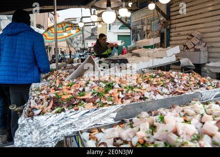 Un homme a vu vendre du poisson frais dans le marché de BallarÚ avant la Saint-Sylvestre. Beaucoup sont allés dans des endroits et des marchés populaires à l'approche du nouvel an. Banque D'Images