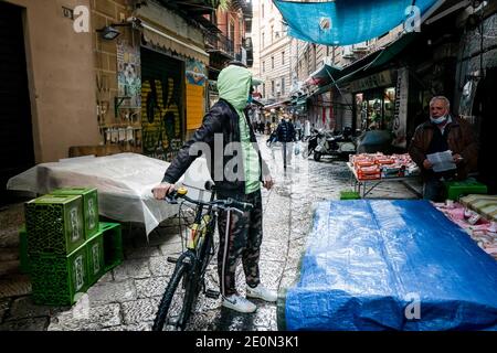 Un homme avec un vélo vu au marché de Vucciria avant la Saint-Sylvestre. Beaucoup sont allés dans des endroits et des marchés populaires à l'approche du nouvel an. Banque D'Images