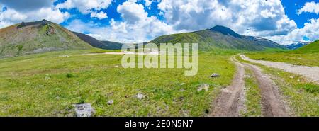 Steppe alpine au fond de montagnes enneigées. Montagnes de l'Altaï, Russie. Banque D'Images