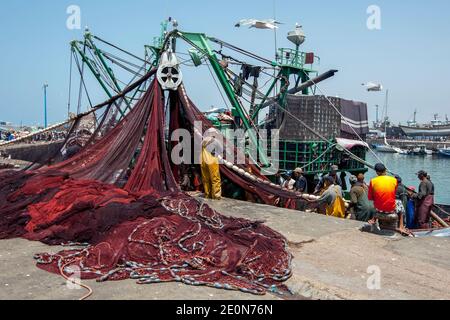 Les pêcheurs retournent dans un chalutier de pêche avec leurs prises au port d'Essaouira, sur la côte atlantique du Maroc. Banque D'Images