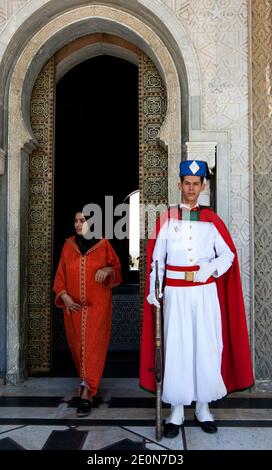 Un visiteur du mausolée de Mohammed V à Rabat au Maroc passe devant l'un des gardes à l'entrée des bâtiments. Banque D'Images