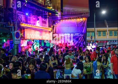 Thaïlandais assis sur la table et de boire de la bière à Route de Khao San Banque D'Images