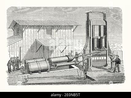 Une ancienne gravure de travailleurs utilisant une presse hydraulique de pressage à vapeur dans les années 1800. Il est issu d'un livre victorien d'ingénierie mécanique des années 1880. La vapeur active est admise dans les cylindres et chambres horizontaux (à gauche). Via la tuyauterie de raccordement, la pression créée force les pistons hydrauliques verticaux (à droite) à pousser vers le bas, comprimant les balles de coton (ou autre matériau) maintenues entre les plaques ci-dessous. La balle comprimée obtenue a été plus facile à transporter et à transporter. Banque D'Images