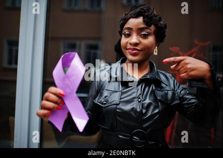 Concept de la Journée mondiale du cancer, février 4. Une femme afro-américaine tient la conscience du ruban violet. Banque D'Images