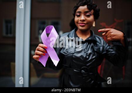 Concept de la Journée mondiale du cancer, février 4. Une femme afro-américaine tient la conscience du ruban violet. Banque D'Images