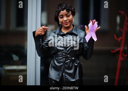 Concept de la Journée mondiale du cancer, février 4. Une femme afro-américaine tient la conscience du ruban violet. Banque D'Images