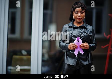 Concept de la Journée mondiale du cancer, février 4. Une femme afro-américaine tient la conscience du ruban violet. Banque D'Images