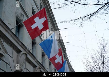 Détail d'un drapeau fédéral suisse et d'un drapeau du canton de Zurich sur la façade d'un bâtiment historique dans le centre-ville de Zurich. Vue à angle bas. Banque D'Images