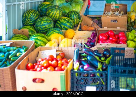 Marché rural de légumes de rue. Les pastèques, les tomates, les aubergines, les concombres, les oignons et l'ail sont en boîtes à vendre. Légumes mûrs, bonne nutrition Banque D'Images