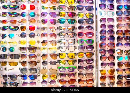 Anapa, Russie - 07.05.2020: Des lunettes de soleil sont suspendues sur un stand à vendre. Grand choix de produits de protection solaire. Marché public Banque D'Images