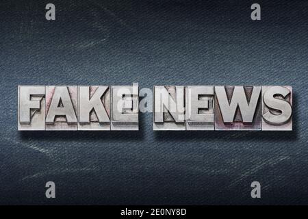 fausses nouvelles phrases faites de typographie métallique sur jean foncé arrière-plan Banque D'Images