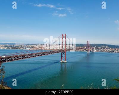Le pont suspendu rouge de Lisbonne par une journée ensoleillée avec le Ville en arrière-plan pont portugais similaire à San Pont Francisco Banque D'Images