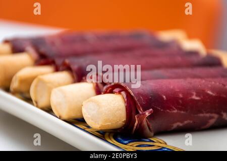 Cecina de León et le jambon se sont roulés dans un en-cas allongé. Vue macro avec flou d'arrière-plan Banque D'Images