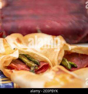 Cecina de León et son jambon aux asperges sauvages se sont roulés dans un en-cas allongé. Vue macro avec arrière-plan non mis au point Banque D'Images