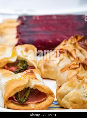 Surface de restauration verticale pour le menu du restaurant. Cecina de león et petits pains au jambon aux asperges sauvages. Mise au point sélectionnée avec arrière-plan blanc. Banque D'Images