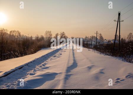 Un chemin de fer recouvert de neige et un chemin de fer trodden par les gens qui le font en hiver. Banque D'Images