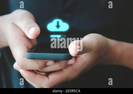 Homme tenant l'icône du nuage de téléphone mobile.Téléchargement de l'application de réseau social en ligne. Banque D'Images