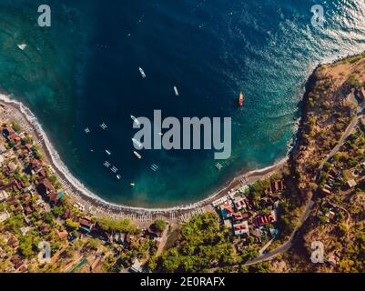 Vue aérienne de la ville balinaise avec mer bleue et bateaux. Amed, Bali Banque D'Images