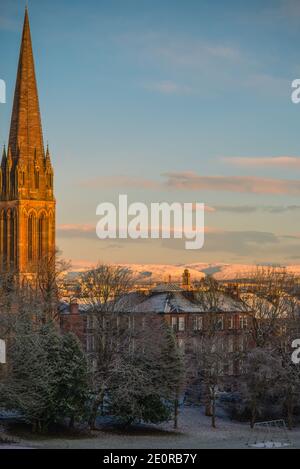 Vue d'hiver sur le Spire de l'église de Glasgow et les sous-sols en grès rouge Avec des collines couvertes de neige en arrière-plan Banque D'Images