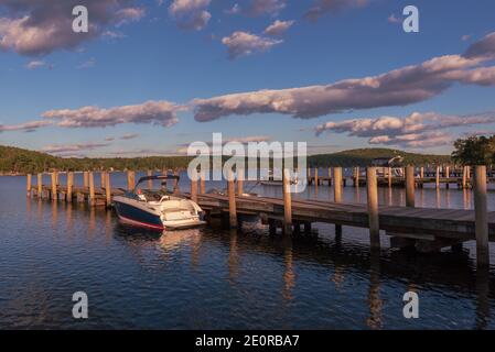 Une photo grand angle d'un bateau amarré à un quai dans le lac Winnipesaukee, NH, un après-midi de fin d'automne alors que le soleil commence à se coucher. Banque D'Images