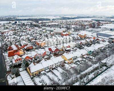 Nupaky, République tchèque. 10 janvier 2019. Nouvelles maisons en rangée colorées avec la vieille partie du village en arrière-plan en hiver avec de la neige Banque D'Images