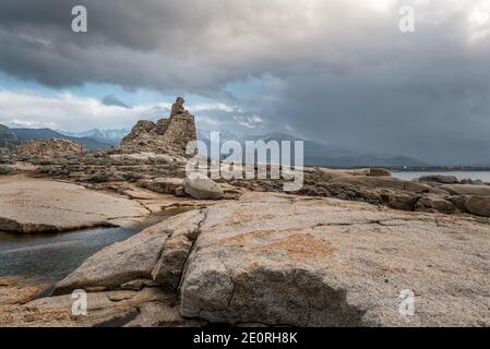 Ancienne tour génoise à Punta Caldanu près de Lumio dans le Balagne région de Corse avec le sommet enneigé de Monte Grosso au loin Banque D'Images