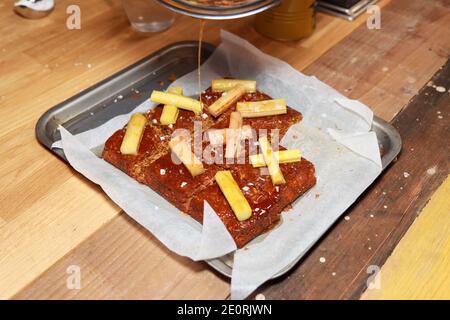 Un trey de parkin traditionnel avec le rhubarbe du yorkshire sur un arrière-plan en bois Banque D'Images