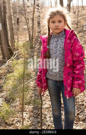 Une petite fille blonde regarde soigneusement au loin. Banque D'Images