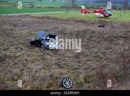 02 janvier 2021, Basse-Saxe, Göttingen : une voiture se trouve loin de la route après un accident, avec un hélicoptère de secours en arrière-plan. Le conducteur de NRW, âgé de 25 ans, avait surpassé l'île de circulation bâtie d'un rond-point et s'était abaissé sur une pente. Selon la police, le passager de 33 ans est décédé sur les lieux. Le conducteur a subi de graves blessures, son permis de conduire a été confisqué. Photo: Stefan Rampfel/dpa Banque D'Images