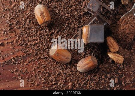 Chocolat noir et noisettes. Barre de chocolat cassée sur la table de cuisine noire Banque D'Images