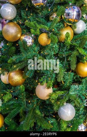 Boule de Noël dorée et argentée sur les branches de sapin, arbre de Noël décoré. Décor de la nouvelle année fond festif avec tons vintage et mise au point sélective. Photo de haute qualité Banque D'Images