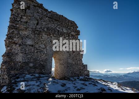 Il reste d'une ancienne forteresse sur les montagnes enneigées sur une journée ensoleillée, les ruines de Rocca Calascio, ancien château dans les Abruzzes, Italie Banque D'Images