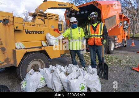 NEW YORK, NY – 2 JANVIER : les employés du département des Parcs de New York ont vu avec des sacs de paillis d'arbres pendant le New York City Mulchfest à Astoria Park le 2 janvier 2021 à New York City. Les New-Yorkais peuvent apporter leur arbre et un sac fourre-tout sur un site de chipping et regarder leur arbre être ébréché, puis apporter leur propre paillis riche en éléments nutritifs à la maison avec eux. Parcs et DSNY ont récolté et paillé des arbres pour aider à planter des lits et des jardins communautaires autour de la ville à croître. Crédit : Ron Adar/Alay Live News Banque D'Images